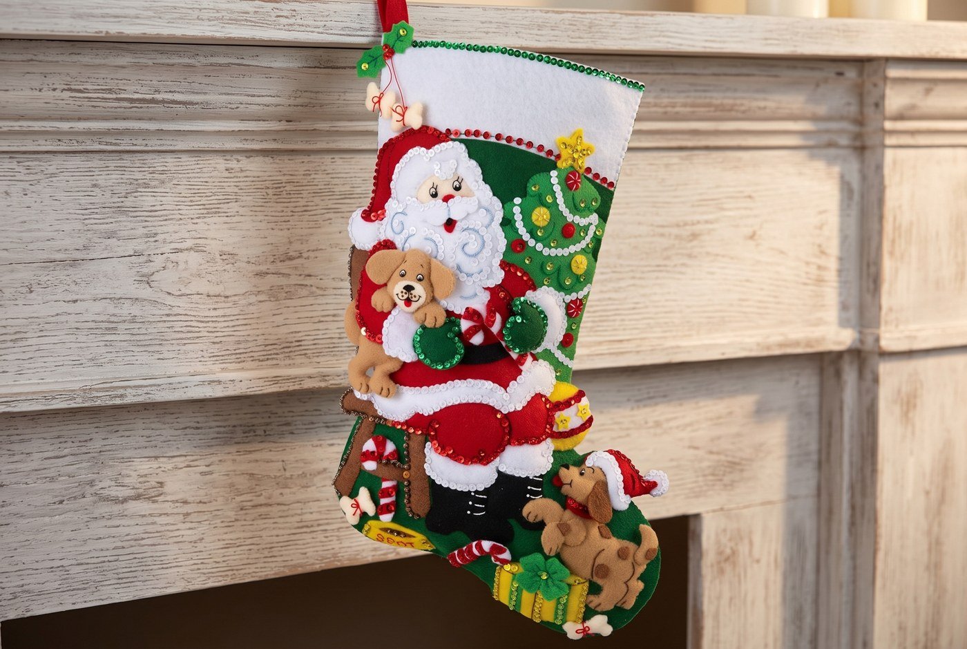Bucilla Jolly Pups Santa felt-applique stocking 89556E — forest green base with Santa cradling a golden puppy and a dachshund in a Santa hat at the bottom, richly embellished